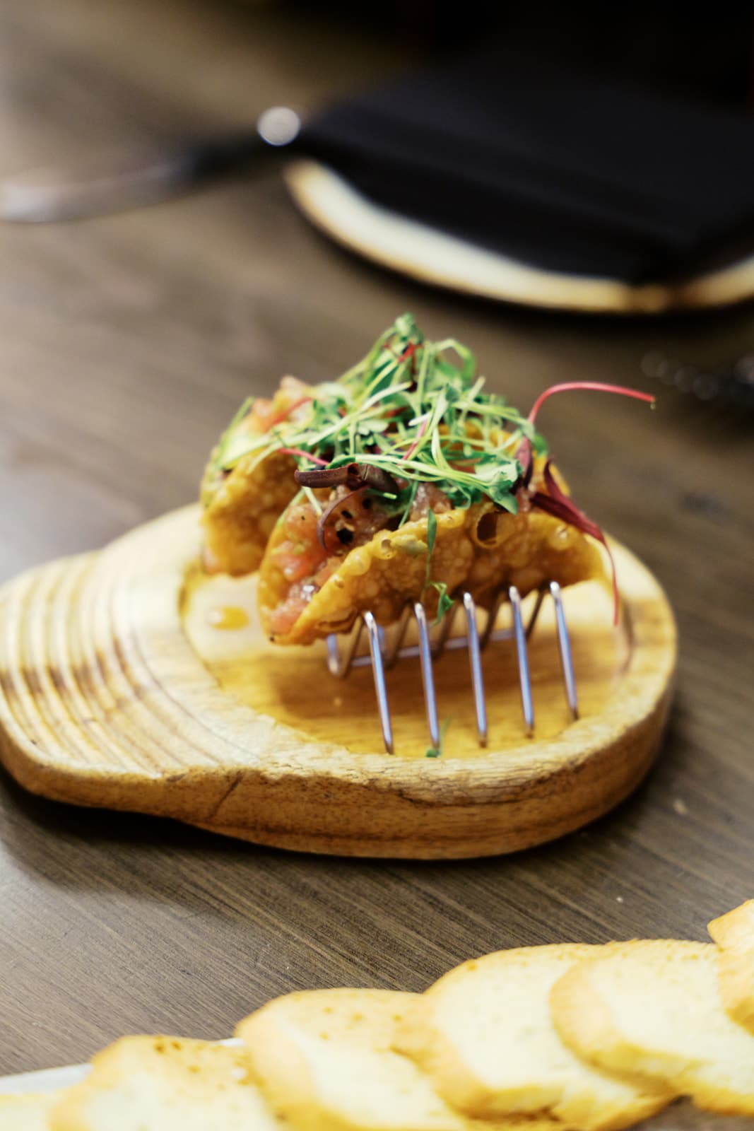 Ahi tuna tacos in a crispy shell sitting on a metal taco stand.