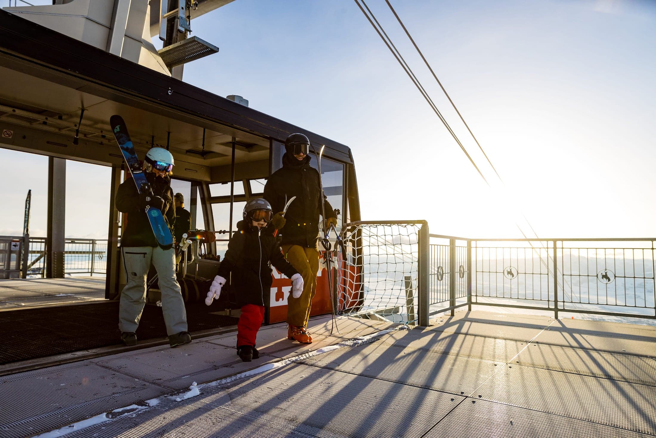A family walking off an aerial tram at the top of the ski hill in Teton mountain lodge
