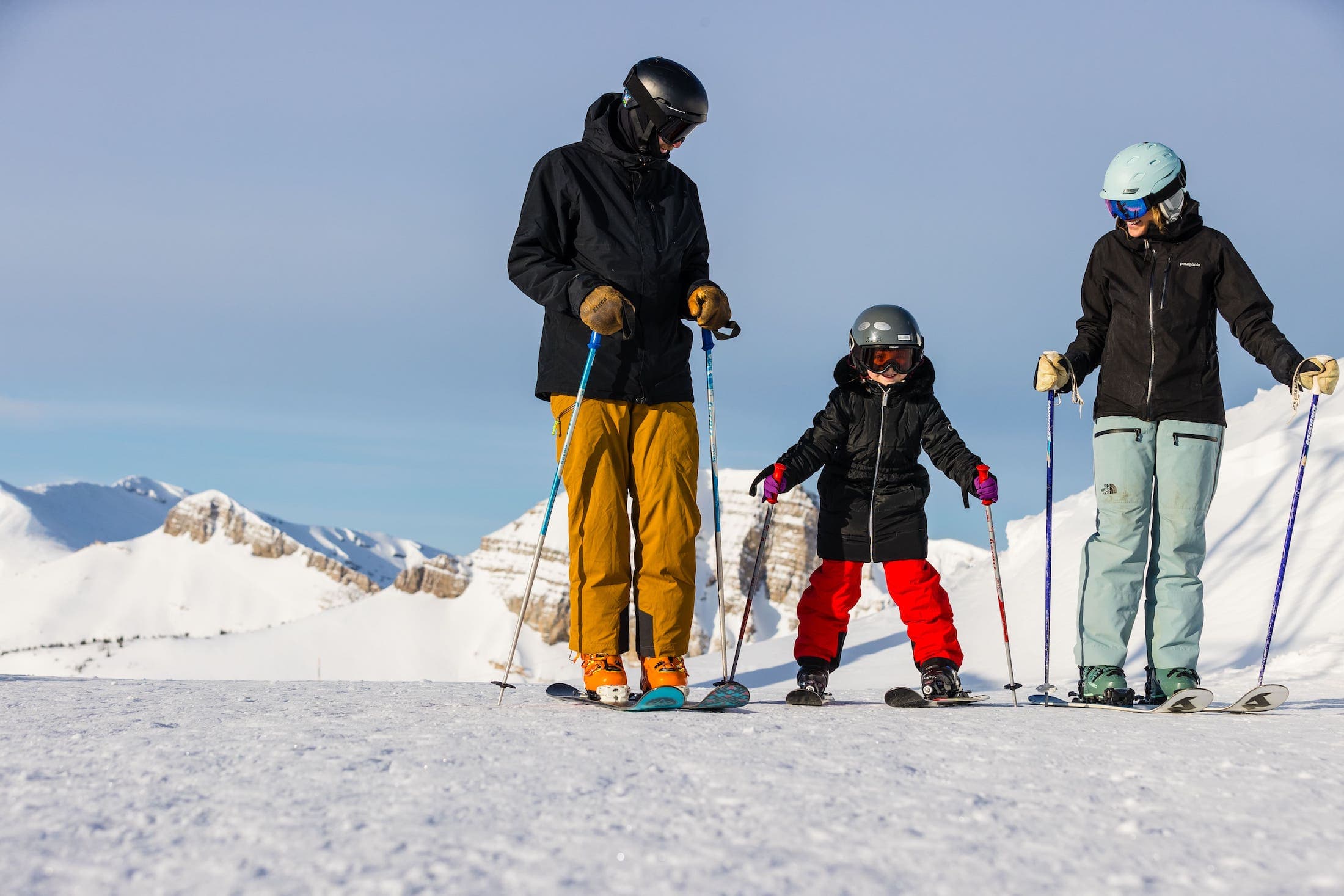 A mother and father teaching their daughter how to ski at Teton Mountain Lodge
