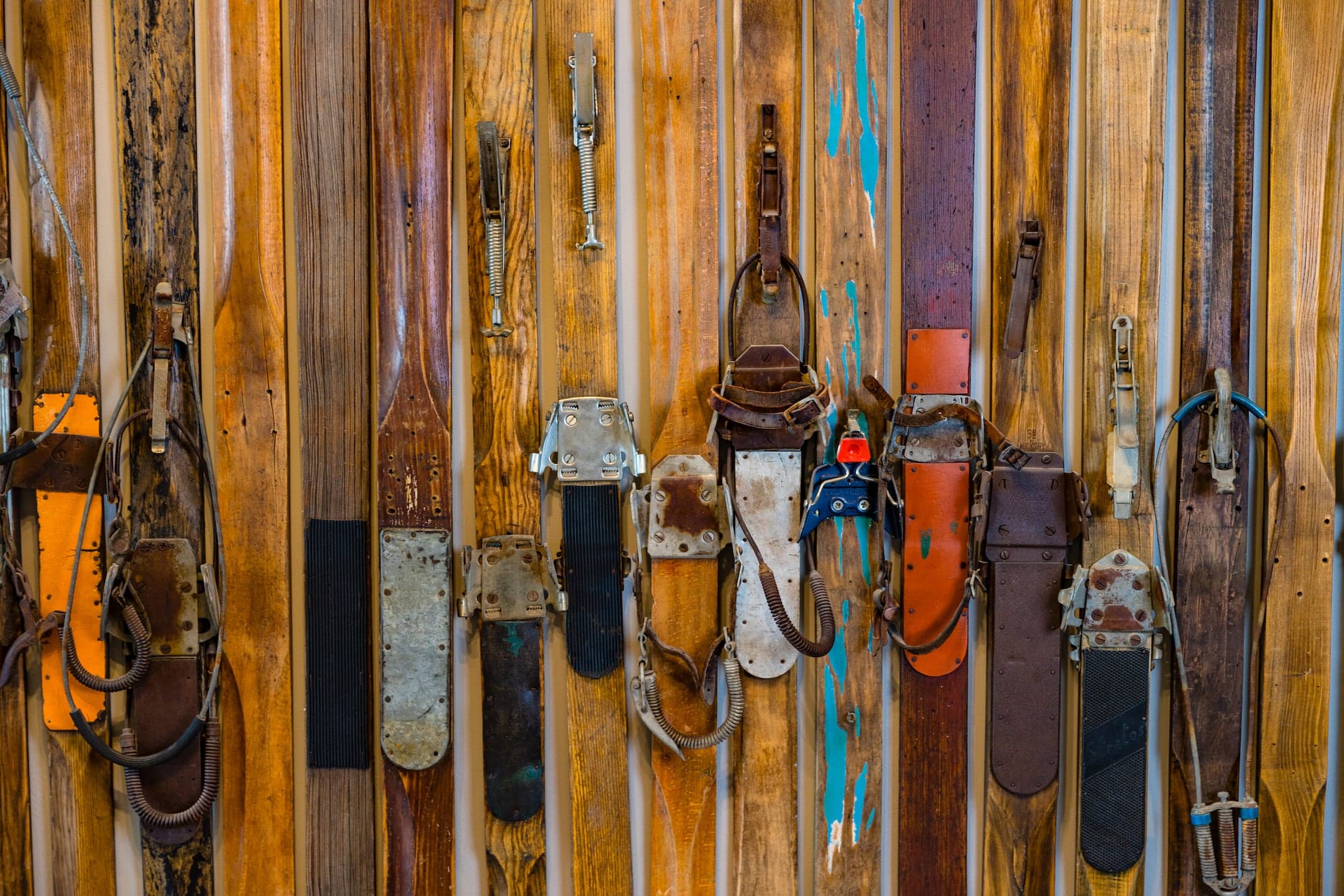 A bunch of vintage skis against a wall
