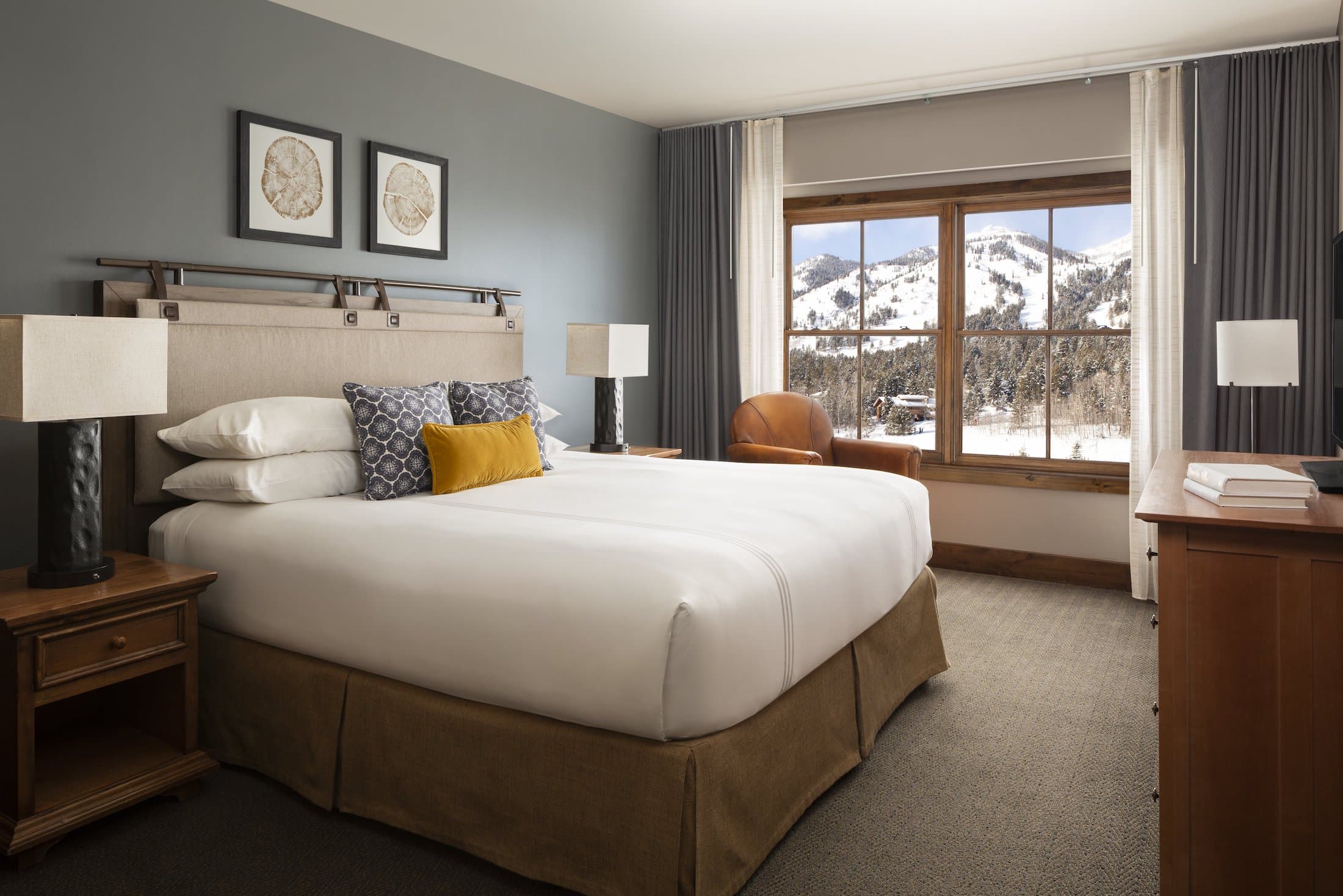 A king bed in a spacious King lodge room with views of the mountains at Teton Mountain Lodge