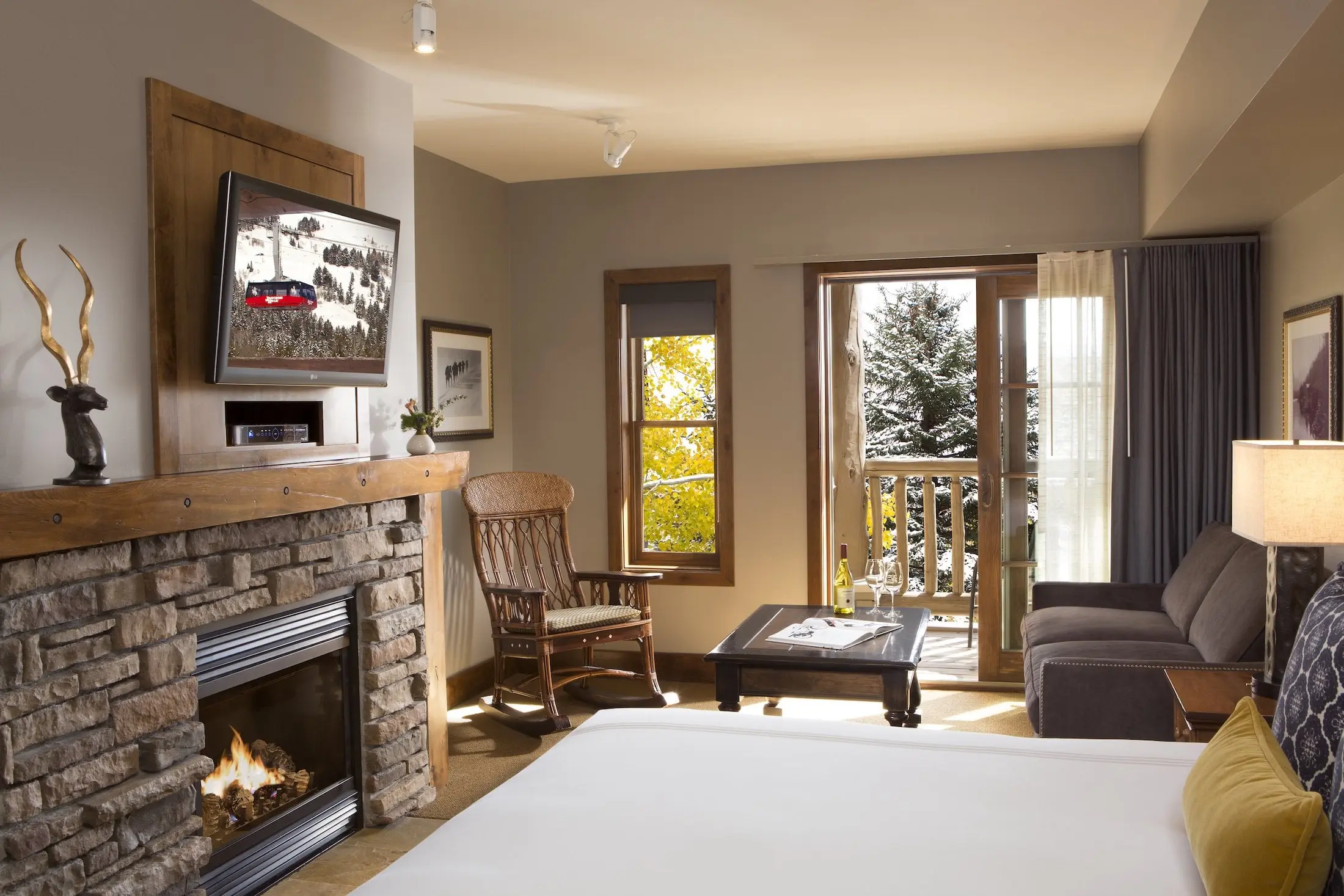 Teton Mountain Lodge Grand King room with a fireplace, couch, and a beautiful view of the outdoors