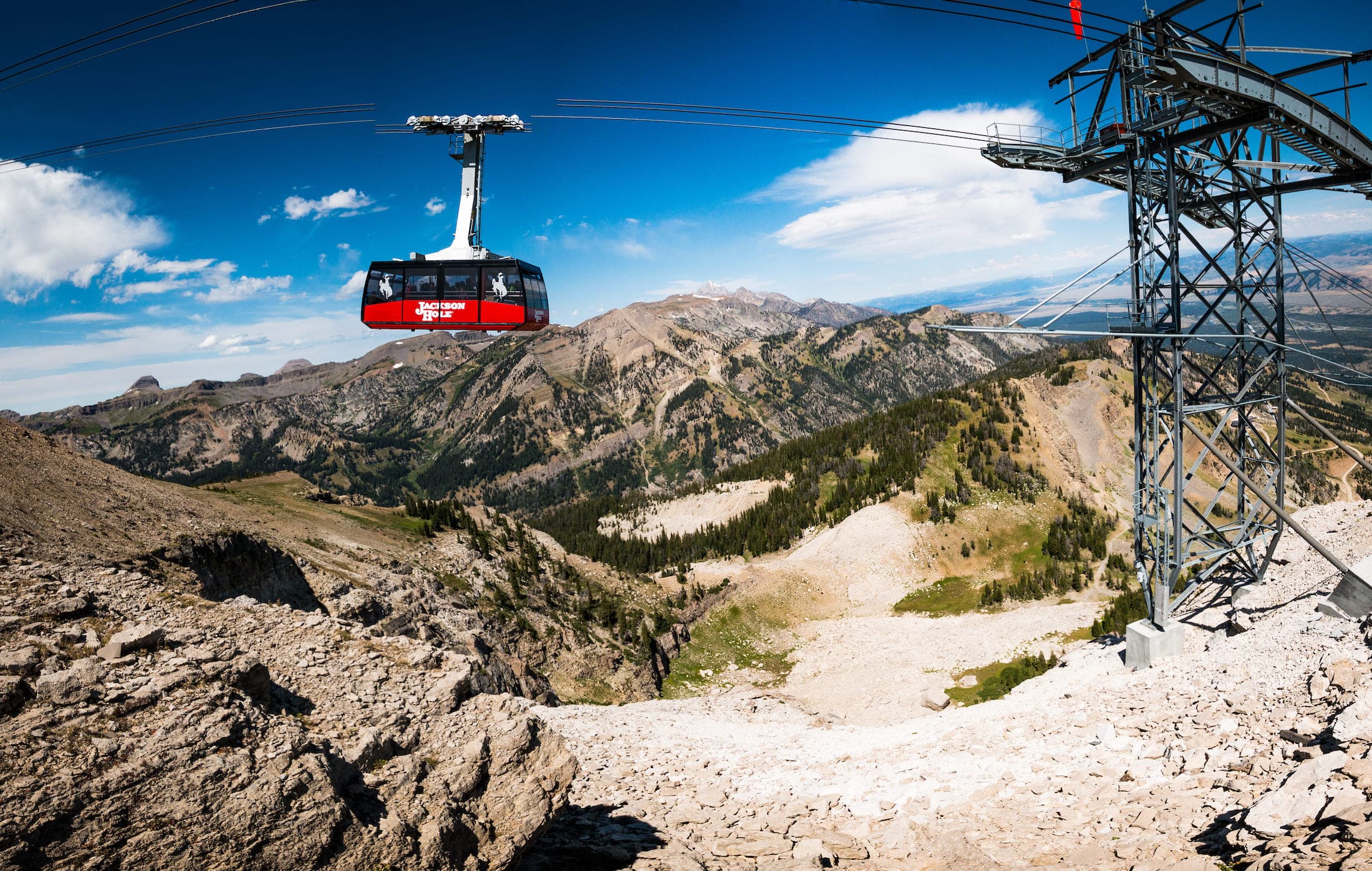 A wide-angle photo of an aerial tram and supporting tower