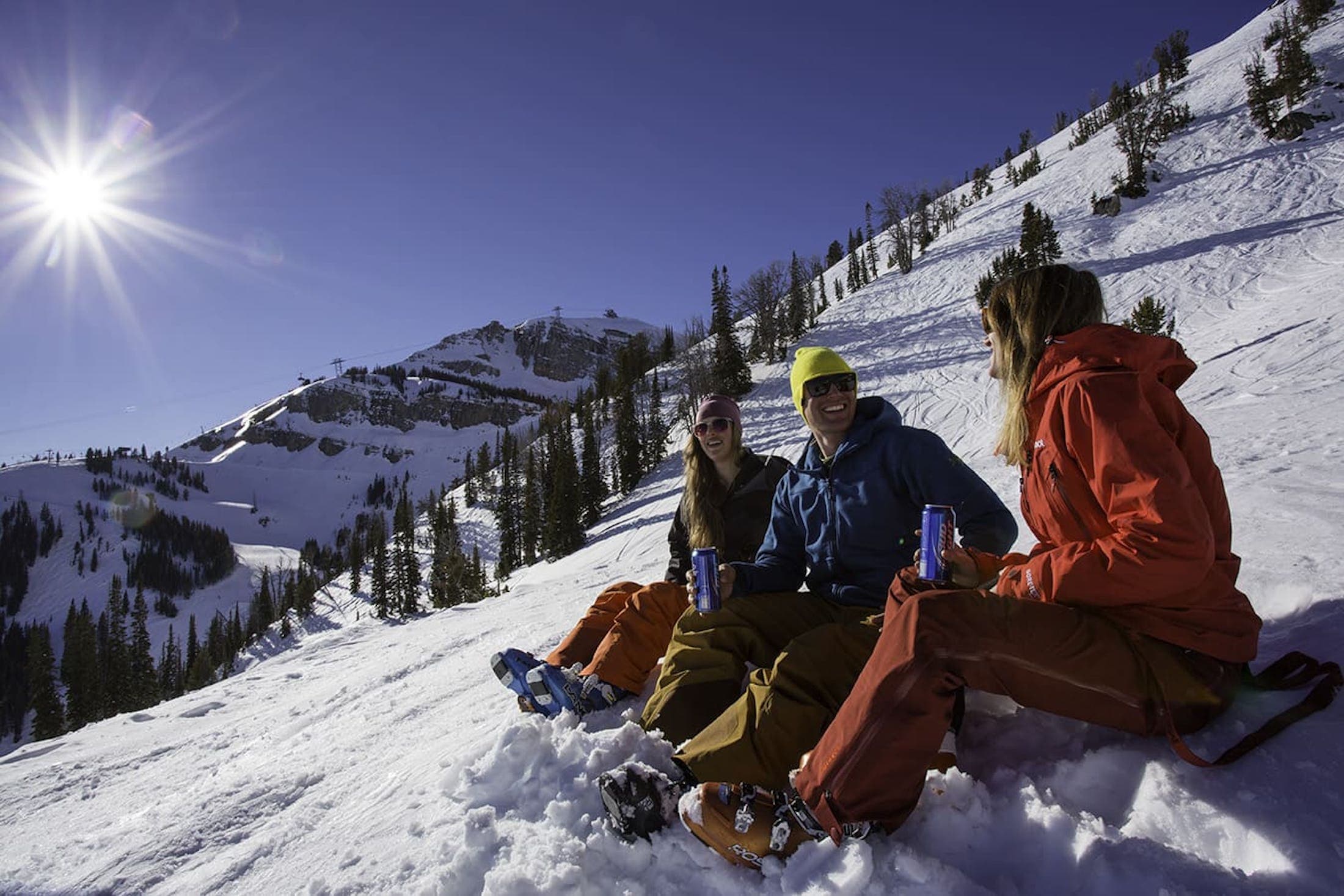 Three skiiers relaxing in the sun at Jackson Hole Mountain Resort.