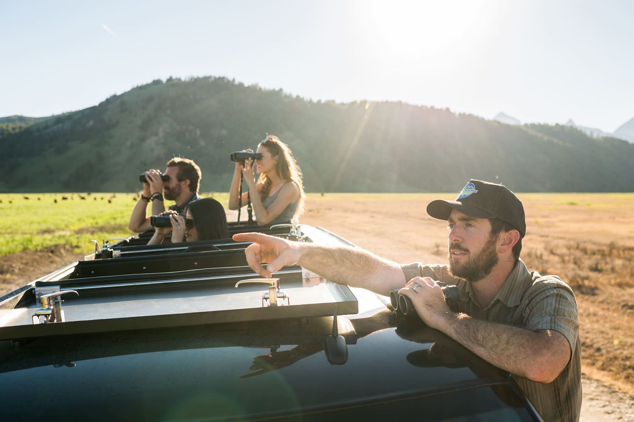 A photo of a wildlife safari with multiple people holding binoculars