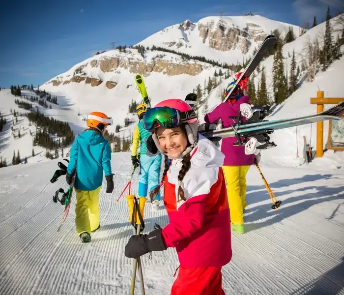 A group of kids about to ski down a groomed ski slope