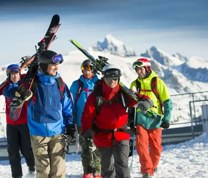 A group of people with helmets and holding skis