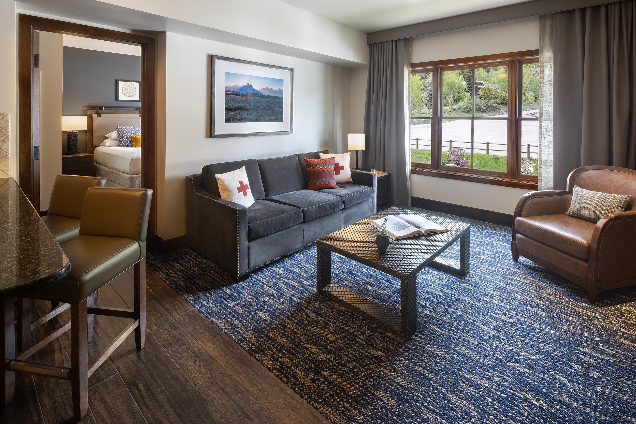 Suite living room with kitchen bar and adjoining bedroom at Teton Mountain Lodge, Jackson Hole